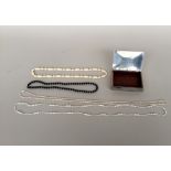Four costume jewellery necklaces in a chrome box by Oria Sweden with wood interior 9x13x3cm