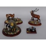 Three resin figurines depicting a stag,