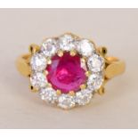 An 18ct gold ladies cluster ring set with a single cut ruby surrounded by ten small cut diamonds