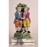 A George III pearlware 'Friendship' group by Walton of two boys in front of a bocage with a cat at