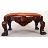 A Dutch walnut and marquetry foot stool on ball and claw feet and with floral inlay,