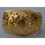 A yellow metal bangle, early 20th century, probably Indian, with pierced foliate decoration, 5.