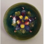 A small Moorcroft bowl with an interior floral decoration on green ground,