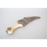 A janbiya dagger with a bone/ivory handle in an ornate scabbard,