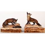 A pair of cold painted bronze figures of foxes on rocky bases, early 20th century, the first 7.
