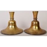 Islamic interest: Two 19th century brass candlesticks of bell form with finely pricked out foliate