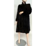 A circa 1930s black fur and satin lined calf length coat.