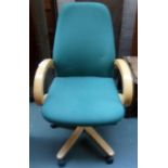 A office chair with green upholstery on casters