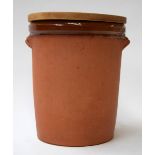 A large terracotta bread bin with wooden lid