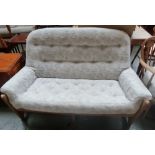 An Ercol two seater sofa with cushioned upholstery,