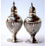 A pair of sterling silver pepper casters made by 'Walker and Hall' c.