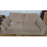 An oatmeal covered two seater sofa,