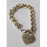 A white metal single chain bracelet with a heart shaped charm engraved 'Please return to Tiffany &