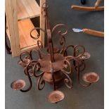 A wrought iron chandelier with space for six candles,