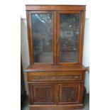 A sideboard with glazed upper section containing two shelves,