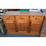 A pine sideboard of three drawers above three cupboard doors