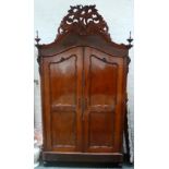 A Baltic mid 19th century mahogany armoire in the Louis XV style with pierced foliate wreath on bun