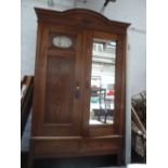 A continental oak two door with carved foliate design to top and mirrored door