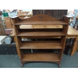 An Edwardian oak bookcase in the Arts and Crafts taste the four shelves on a pegged frame