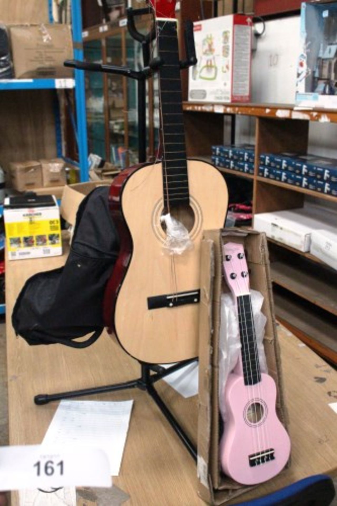 An I Burswood acoustic guitar with broken strings, a pink Martin Smith ukulele and a 3-way guitar