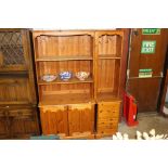 A modern pine bookcase raised on cupboard base tog