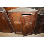 A George III oak hanging corner cupboard