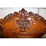 A large ornately carved hardwood headboard togethe