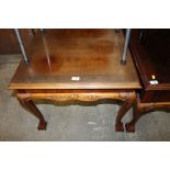 A reproduction mahogany square topped coffee table