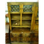 An oak linenfold decorated cabinet on cupboard bas