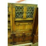 An oak linenfold decorated cabinet on cupboard bas