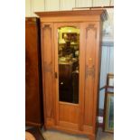 An Edwardian satinwood single door wardrobe