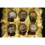 A cased set of six glass internally painted balls