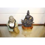 A pottery Buddha and an Indian ornament on stand