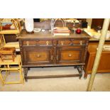 A 20th Century oak two drawer sideboard raised on