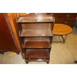 A mahogany waterfall bookcase fitted single drawer