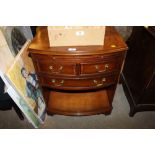 A reproduction yew wood bow front chest