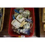 A red basket of decorative china and ornaments