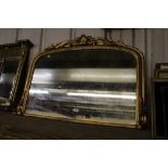 An ornate gilt framed over mantel mirror