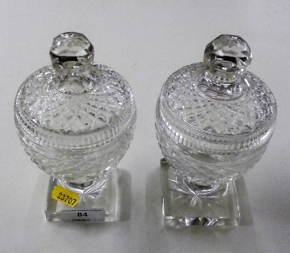 A pair of 19th Century cut glass jars and covers