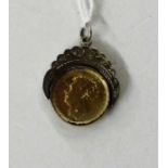 A yellow metal coin pendant