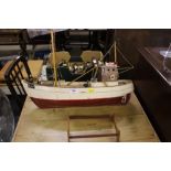 A painted wooden model boat on stand