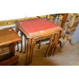 A nest of three glass topped occasional tables