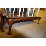 A low mahogany oblong coffee table raised on paw s