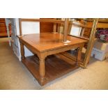 An oak square topped two tier coffee table