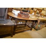 An oak oval topped dining table united by stretche