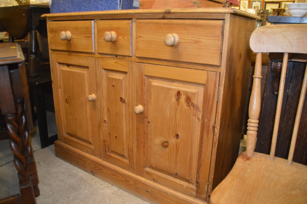 A stripped pine three drawer sideboard