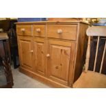 A stripped pine three drawer sideboard