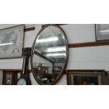 An Edwardian mahogany and inlaid oval wall mirror