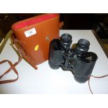 A pair of Crown binoculars in leather carrying cas