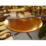 A large mahogany and inlaid circular topped dining